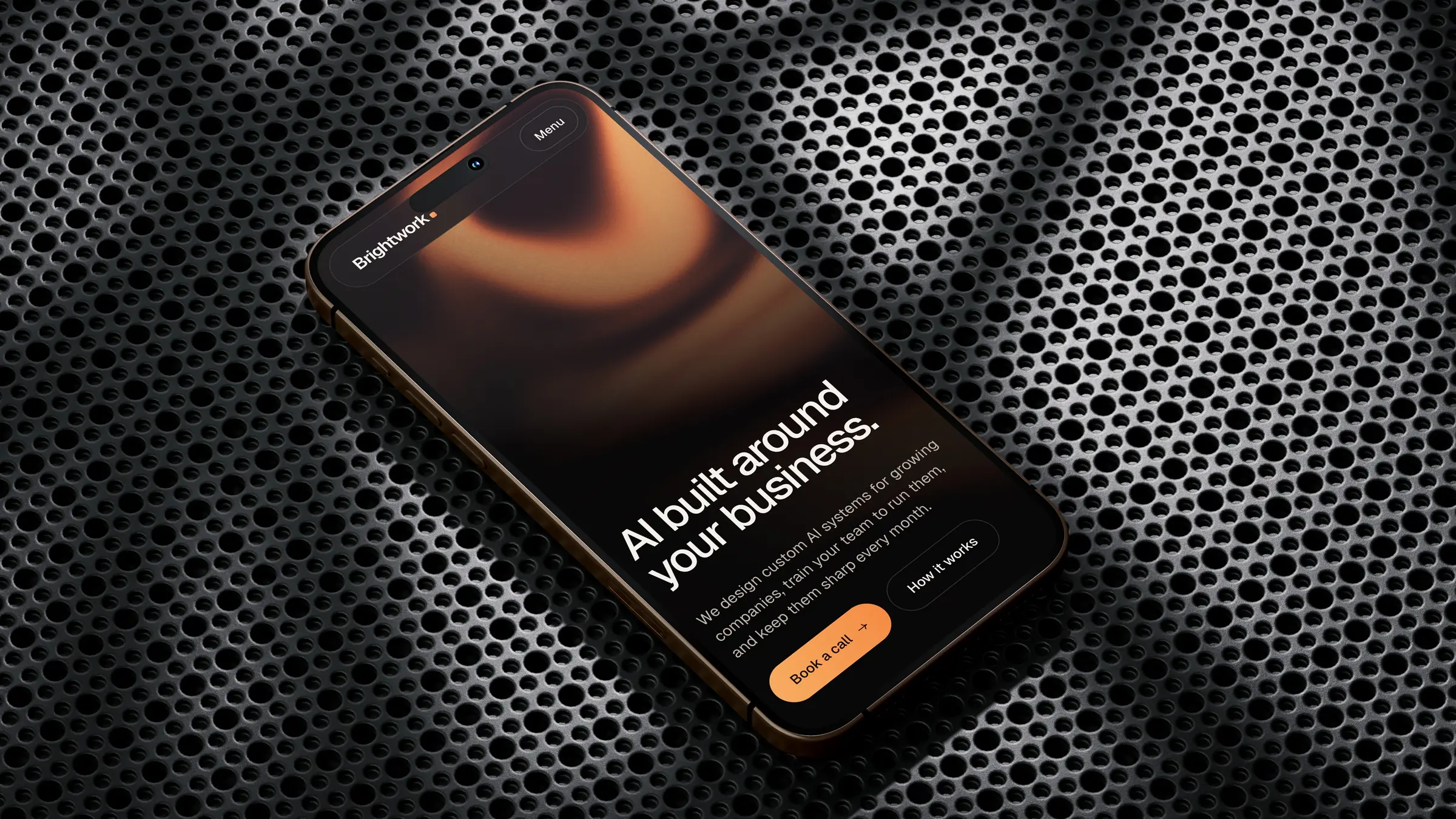 Brightwork homepage on a phone lying on black perforated metal