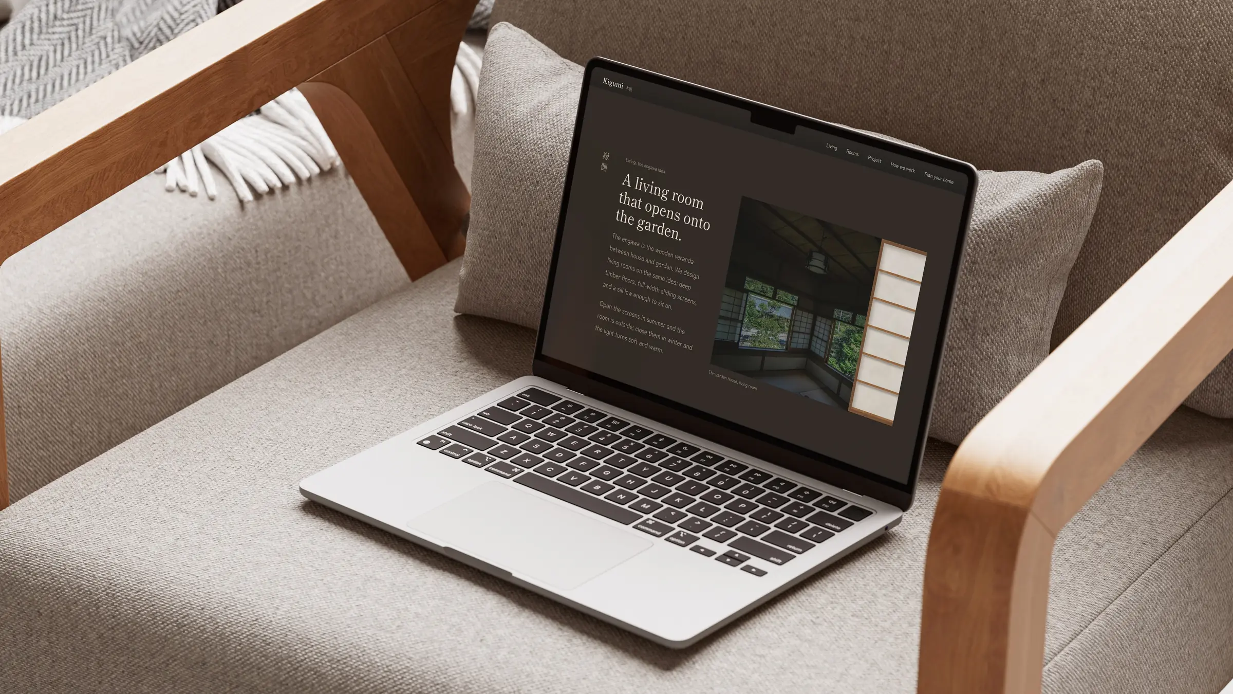 MacBook に表示した Kigumi の居間のセクション。見出し A living room that opens onto the garden. 木のアームチェアの上